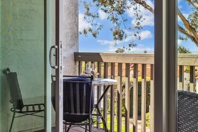 a porch with a table and a chair on a balcony at 2BR Condo with Views Near Shops and Food, Fast WiFi in Carlsbad