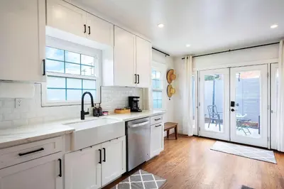 a kitchen with white cabinets and a sink at The Captain Quarters- Rosecrans Marina Escape in San Diego