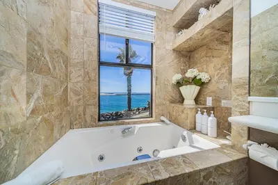 a bathroom with a tub and a window and the ocean at Ocean Vista Penthouse 2 in San Diego