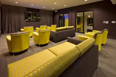a waiting room with yellow chairs and couches at Ariva in San Diego