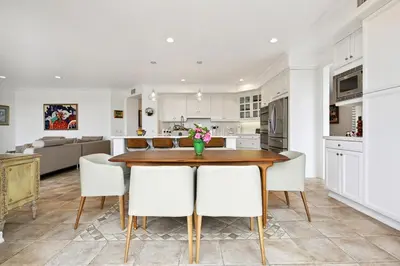 a kitchen and living room with a wooden table and chairs at Exquisite Panoramic View Estate in Newport Beach