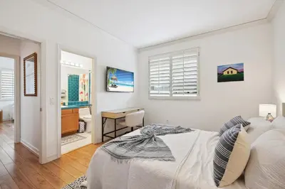 a white bedroom with a bed and a desk at Exquisite Panoramic View Estate in Newport Beach