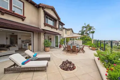 a patio with chairs and a fire pit in front of a house at Exquisite Panoramic View Estate in Newport Beach