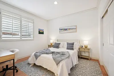 a bedroom with a bed and a desk and a window at Exquisite Panoramic View Estate in Newport Beach