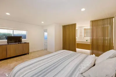 a bedroom with a large bed and a television at Aqua Luxe - SUR113 in Solana Beach