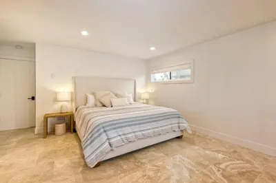 a bedroom with a bed and a window on the wall at Aqua Luxe - SUR113 in Solana Beach