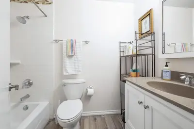 a white bathroom with a toilet and a sink at 5 Bedroom Home With Firepit in San Diego