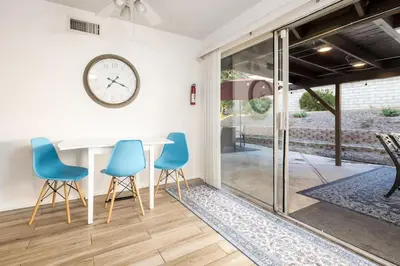 a dining room with blue chairs and a clock on the wall at 5 Bedroom Home With Firepit in San Diego