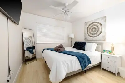 a white bedroom with a bed and a ceiling fan at 5 Bedroom Home With Firepit in San Diego