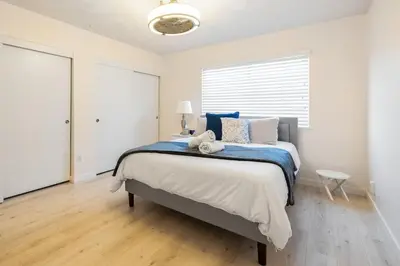 a bedroom with a large bed with blue and white pillows at 5 Bedroom Home With Firepit in San Diego
