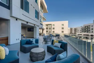 a balcony with blue chairs and tables on a building at Vive Luxe in San Diego
