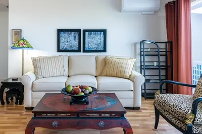 a living room with a couch and a bowl of fruit on a table at #Marbella Lane - Bayfront Bliss Sunset Views & Pool in San Diego
