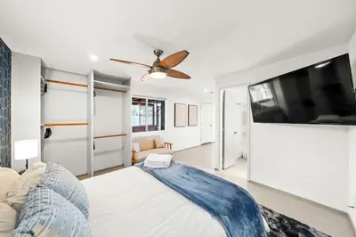 a living room with a bed and a flat screen tv at Westinghouse Park Retreat Decks, BBQ, Fire Pits in San Diego