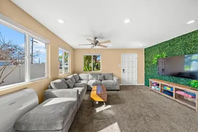 a living room with a couch and a flat screen tv at Westinghouse Park Retreat Decks, BBQ, Fire Pits in San Diego