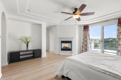 a bedroom with a ceiling fan and a fireplace at Luxury Gated Retreat Views Trails & Resort Pool in Carlsbad