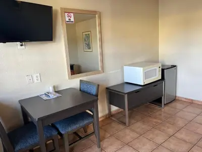 a room with a desk and a microwave and a table at Star Motel in San Diego