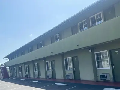 a large building with green doors and windows at Star Motel in San Diego
