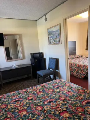 a hotel room with a bed and a chair and a mirror at Star Motel in San Diego