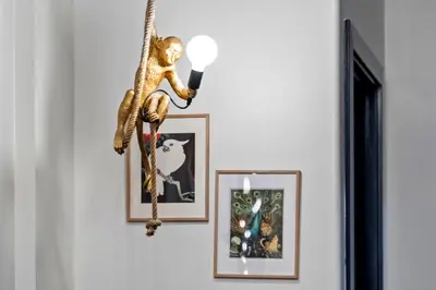 a monkey hanging on a wall with pictures at The Neon Elm Hotel in San Diego