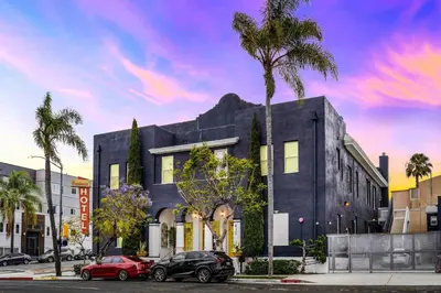 a building with two cars parked in front of it at The Neon Elm Hotel in San Diego