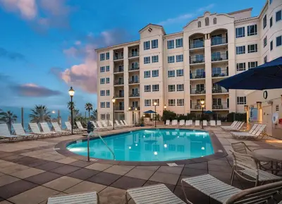 a hotel with a swimming pool in front of a building at Wyndham Oceanside Pier 2BR Apartment with Resort Access in Oceanside