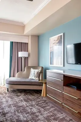 a living room with a couch and a flat screen tv at Wyndham Harbour Lights Studio Apartment with Resort Access in San Diego