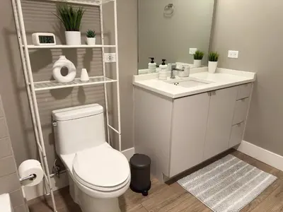 a bathroom with a white toilet and a sink at NEW Upscale Downtown San Diego Stay Queen Bed Pool & Sauna in San Diego