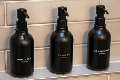 three black bottles sitting on a shelf at Beautiful cozy home in San Diego in San Diego
