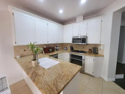 a kitchen with white cabinets and a granite counter top at Family-Friendly Sunny SD Escape, Sleeps 8, Beach, Zoo, Downtown & Convention Center in San Diego