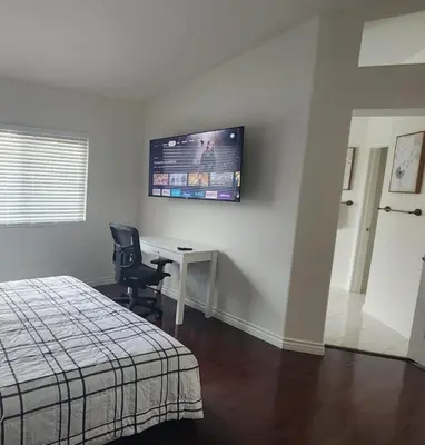 a bedroom with a desk and a television on the wall at Family-Friendly Sunny SD Escape, Sleeps 8, Beach, Zoo, Downtown & Convention Center in San Diego
