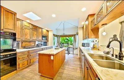 a large kitchen with wooden cabinets and a sink at Spacious 5BD Ocean Views Pool Jacuzzi in San Diego