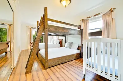 a bedroom with a four poster bed and a crib at Spacious 5BD Ocean Views Pool Jacuzzi in San Diego