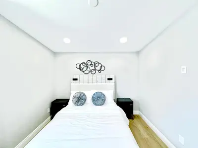 a bedroom with a white bed with blue pillows at Xlnc Exotic home Poway in Poway