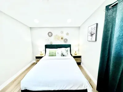 a bedroom with a large bed with green curtains at Xlnc Exotic home Poway in Poway