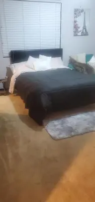 a large bed in a bedroom with a large window at Galaxy House in Sun City