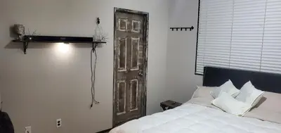 a bedroom with a white bed and a wooden door at Galaxy House in Sun City