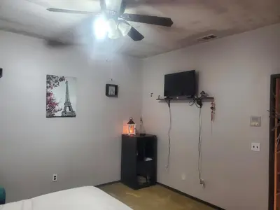 a bedroom with a ceiling fan and a television at Galaxy House in Sun City