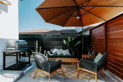 a patio with a table and chairs and an umbrella at Chic Casita w BBQ, Patio, Backyard - 4 min to SDSU, 15 mins to beach, Unit B in La Mesa