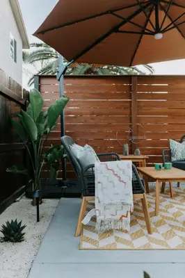 a patio with a chair and a table and an umbrella at Chic Casita w BBQ, Patio, Backyard - 4 min to SDSU, 15 mins to beach, Unit B in La Mesa