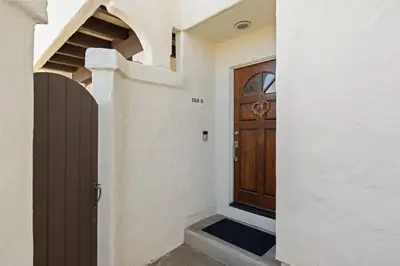a wooden door in a white house with stairs at Carlsbad's Hidden Escape in Carlsbad