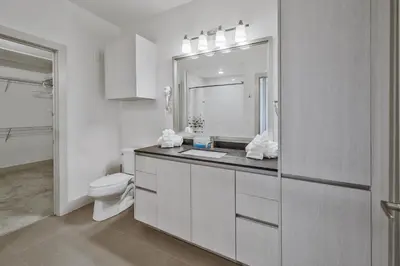 a white bathroom with a toilet and a sink at Global Luxury Suites Mission Valley East in San Diego