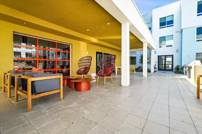 a patio with chairs and tables on a building at Global Luxury Suites near Liberty Station in San Diego