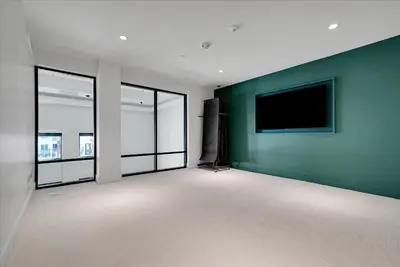 an empty room with a flat screen tv on a green wall at Global Luxury Suites near Liberty Station in San Diego