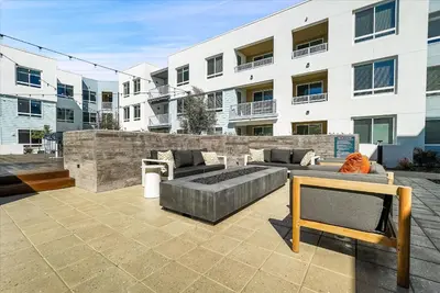 a patio with two couches and a fire pit in front of a building at Global Luxury Suites near Liberty Station in San Diego