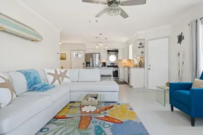 a living room with a white couch and a blue chair at Luxury Oceanfront steps to Beach & Town, Best views! in Oceanside