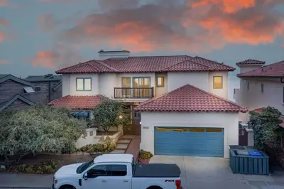 a white truck parked in front of a house at 4 Bedroom With Pool in Oceanside