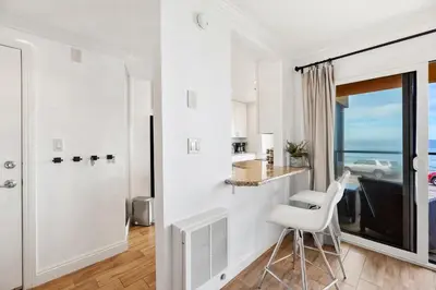a white room with a white chair and a window at Oceanfront La Jolla Cove Condo in San Diego