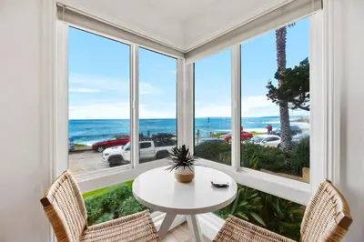 a room with a table and chairs and a large window at Oceanfront La Jolla Cove Condo in San Diego