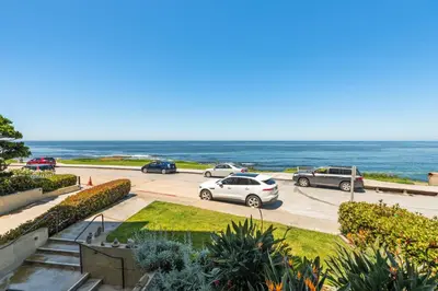 a group of cars parked in a parking lot next to the ocean at Oceanfront La Jolla Cove Condo in San Diego