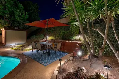 a patio with a table with an umbrella next to a pool at San Diego 4-Bedroom Home with POOL and Jacuzzi in Rancho Bernardo